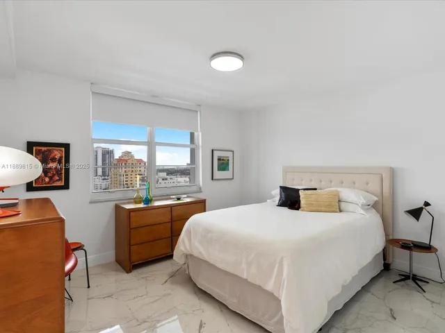 a bedroom with a bed and a large window