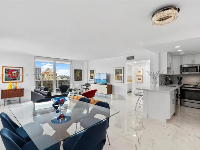a living room with furniture kitchen view and a large window