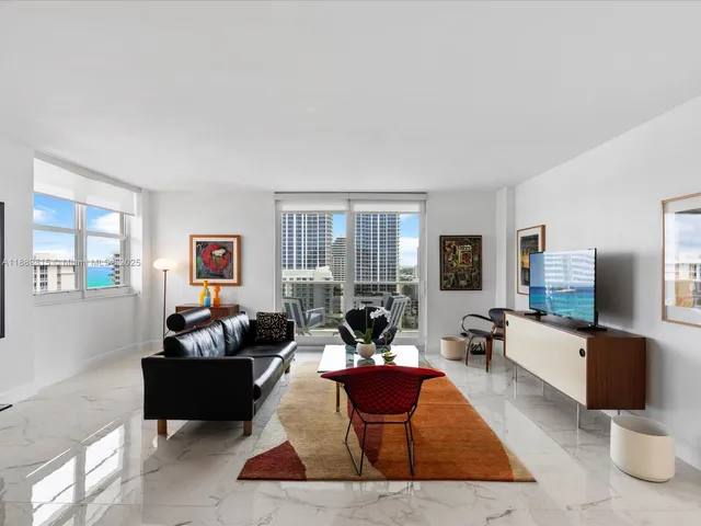 a living room with furniture a large window and a flat screen tv