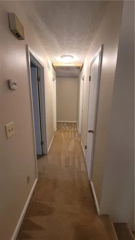 a view of an empty room with a chandelier fan