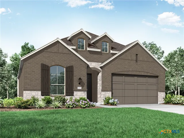 a front view of a house with a garden and yard