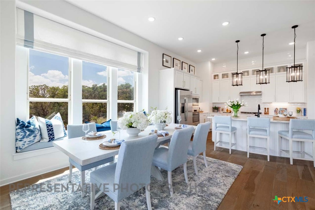 840 Jackson River Loop Kyle, TX 78640 - Photo 20 of 31 a view of a dining room with furniture large windows and wooden floor