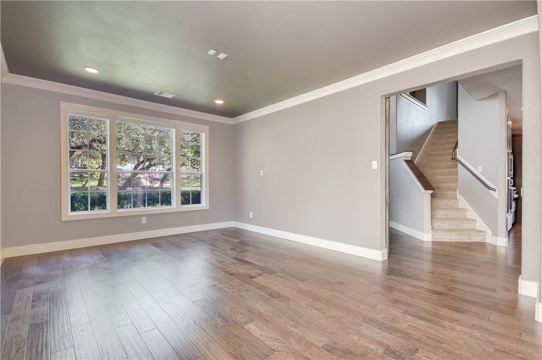 3513 Grimes Ranch Road Austin, TX 78732 - Photo 4 of 32 Spare room with crown molding, baseboards, wood finished floors, stairway, and recessed lighting
