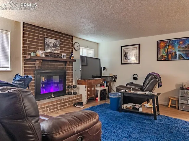 a living room with furniture a flat screen tv and a fireplace