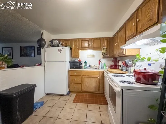 a kitchen with a refrigerator and a stove top oven