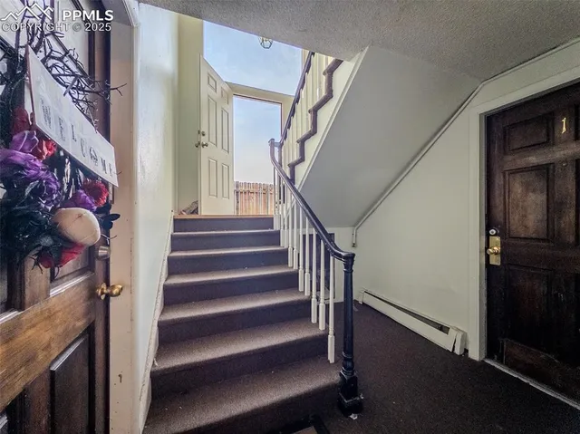 a view of staircase with lots of frames on wall and a window