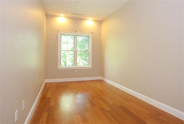 655 East 2nd Street, Unit 209 Boston, MA 02127 - Photo 10 of 16 an empty room with wooden floor and windows