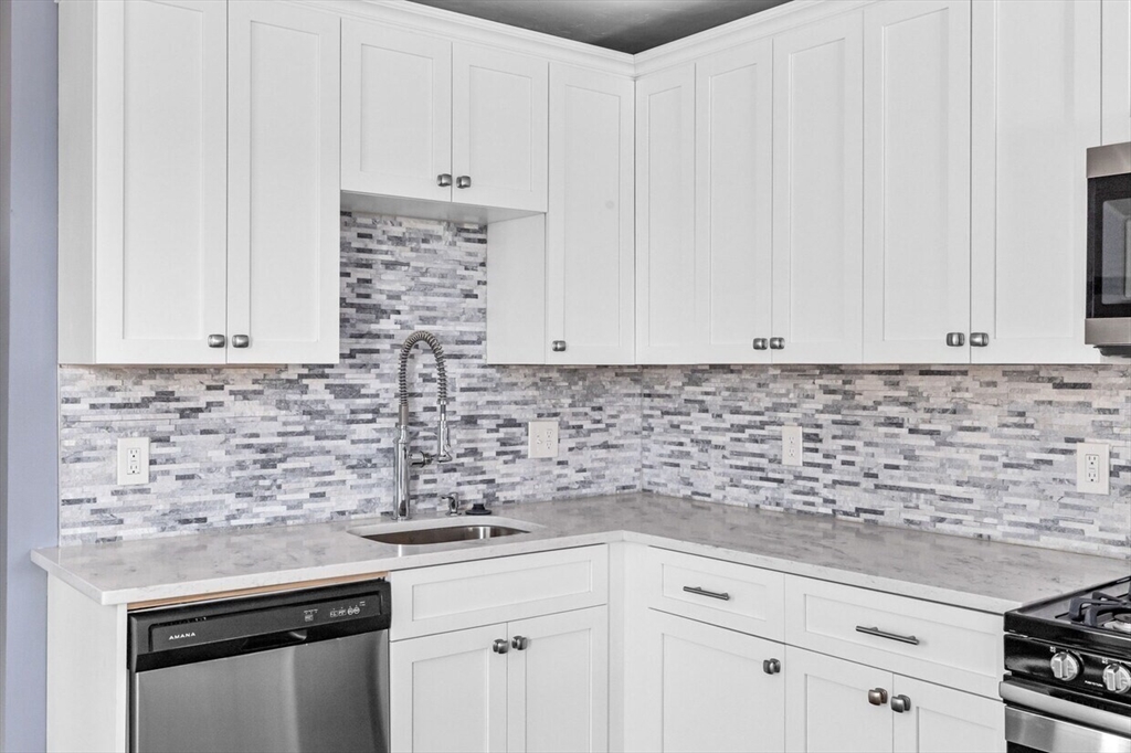 167 Lexington Street, Unit 167 Boston, MA 02128 - Photo 29 of 34 a kitchen with granite countertop white cabinets and white appliances