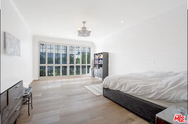 a spacious bedroom with a bed and wooden floor