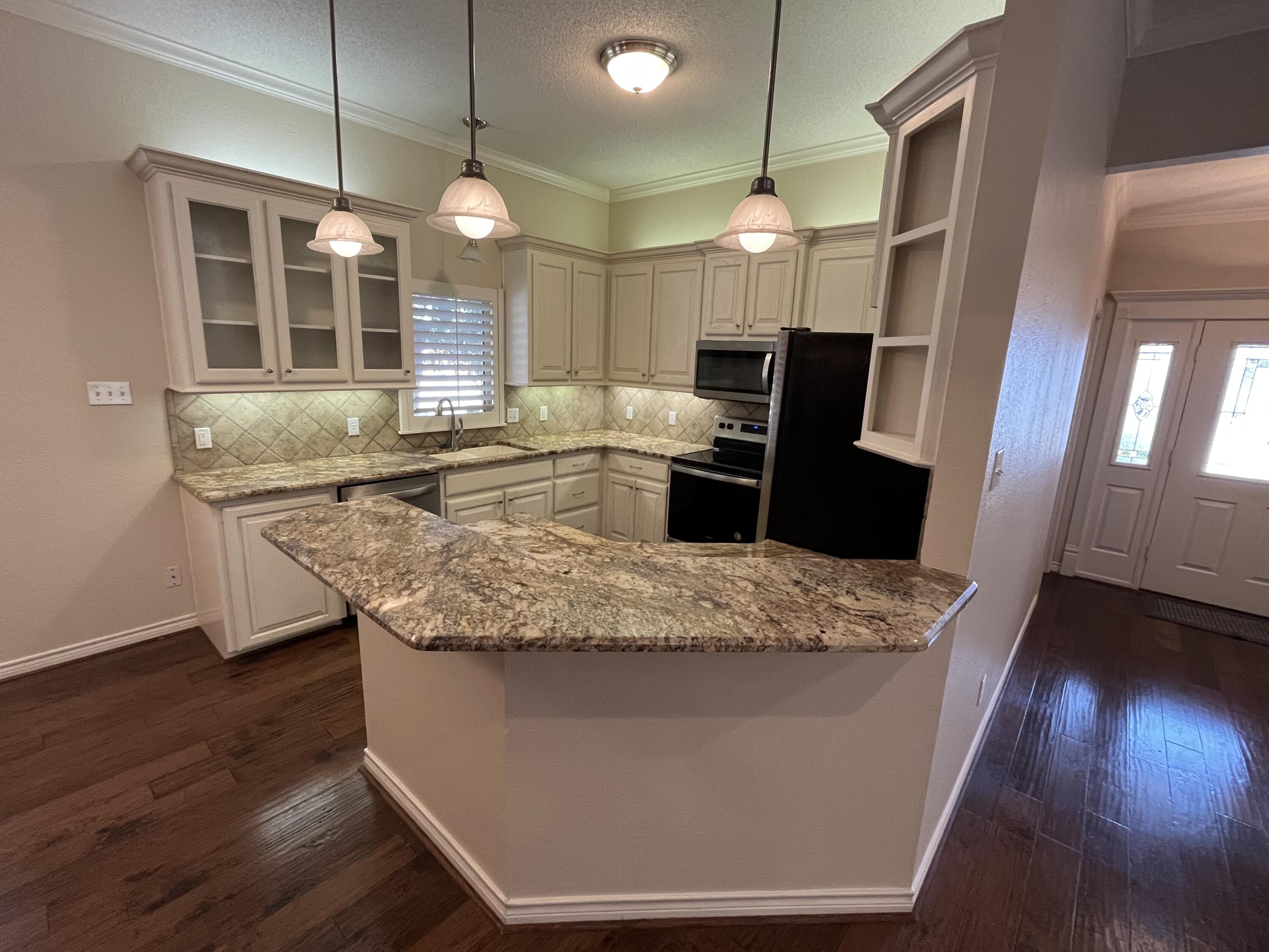 10602 Wayne Avenue Lubbock, TX 79424 - Photo 4 of 17 a kitchen with granite countertop sink and refrigerator