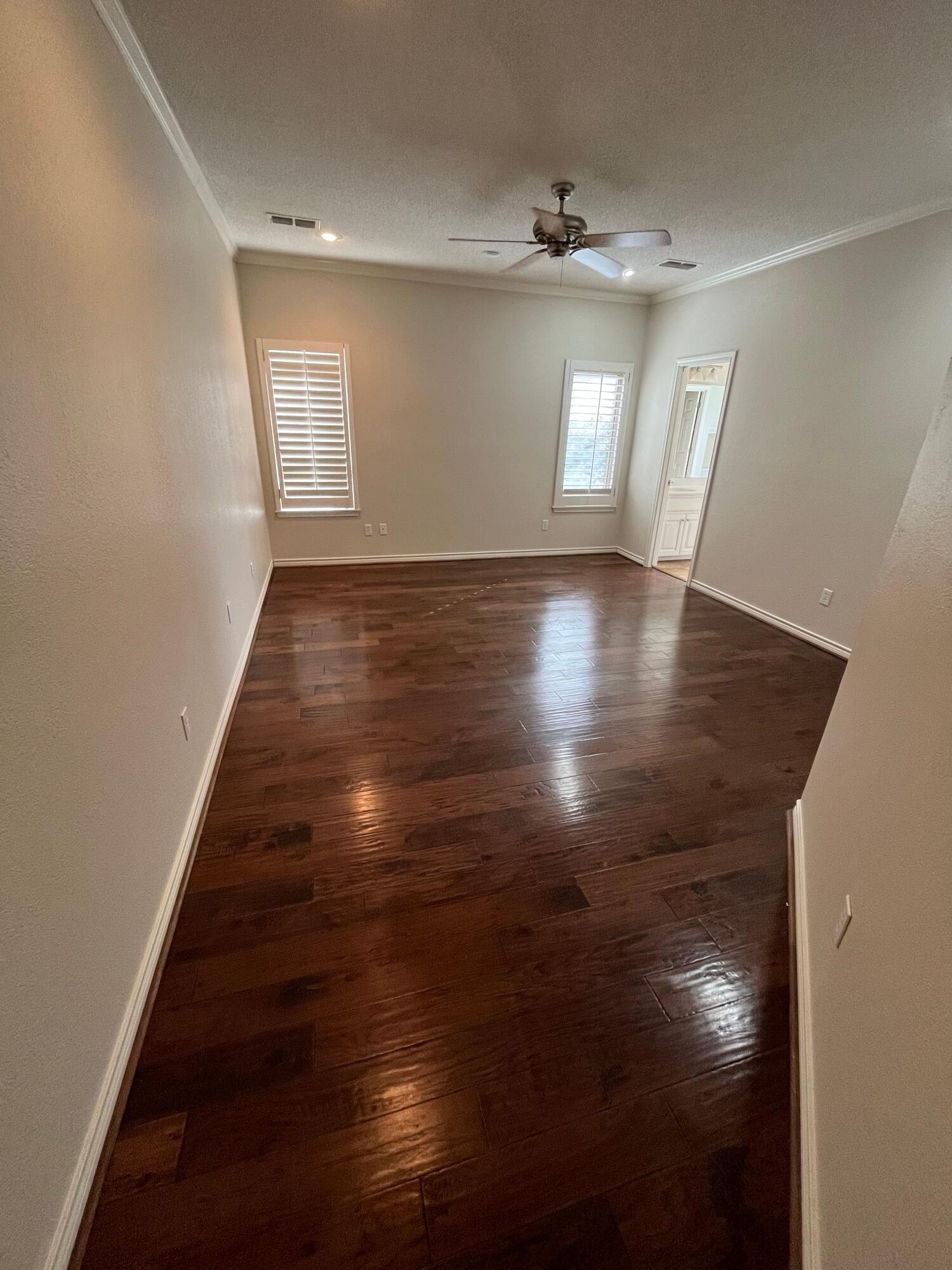 10602 Wayne Avenue Lubbock, TX 79424 - Photo 6 of 17 an empty room with wooden floor and windows