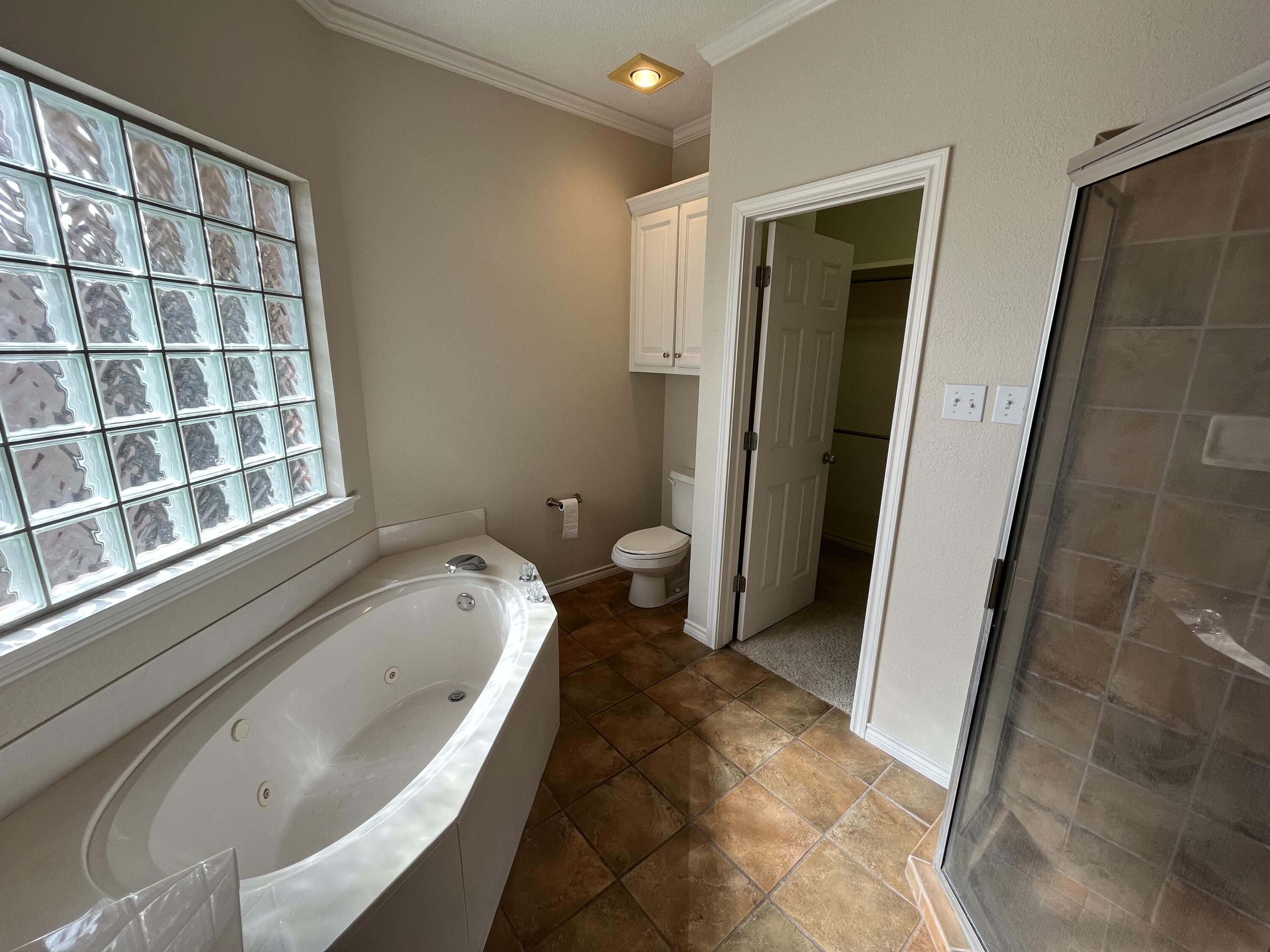 10602 Wayne Avenue Lubbock, TX 79424 - Photo 8 of 17 a bathroom with a tub and a window