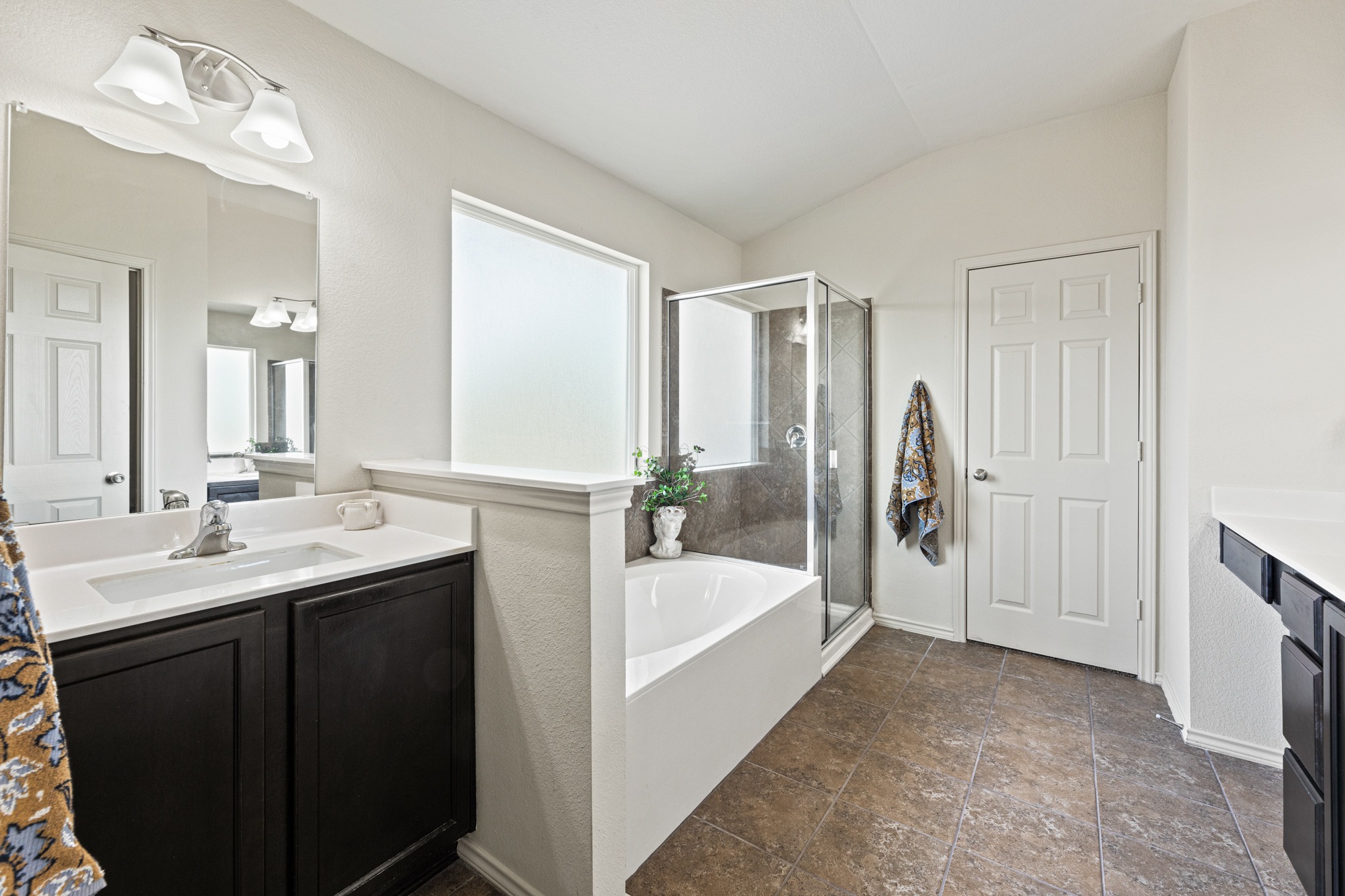 232 Geode Lane Jarrell, TX 76537 - Photo 20 of 39 A spacious primary bathroom layout showcases a soaking tub, glass-enclosed shower, and dual vanities.