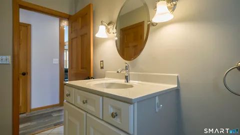 a bathroom with a sink shower and a mirror