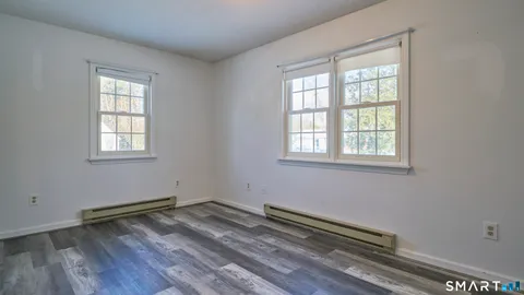 a view of a room with wooden floor and windows