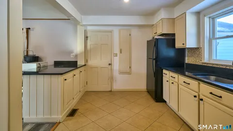 a kitchen with granite countertop a refrigerator and a sink