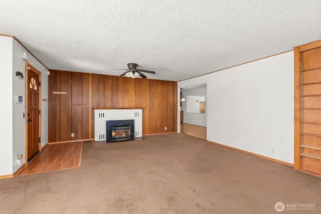 a view of an empty room with a fireplace and a window