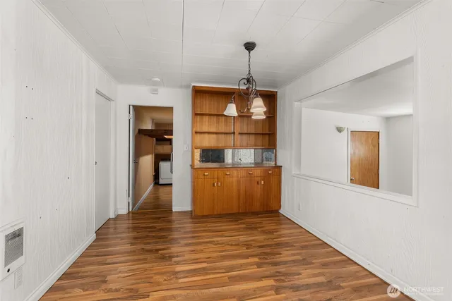 a view of a room with wooden floor and entryway