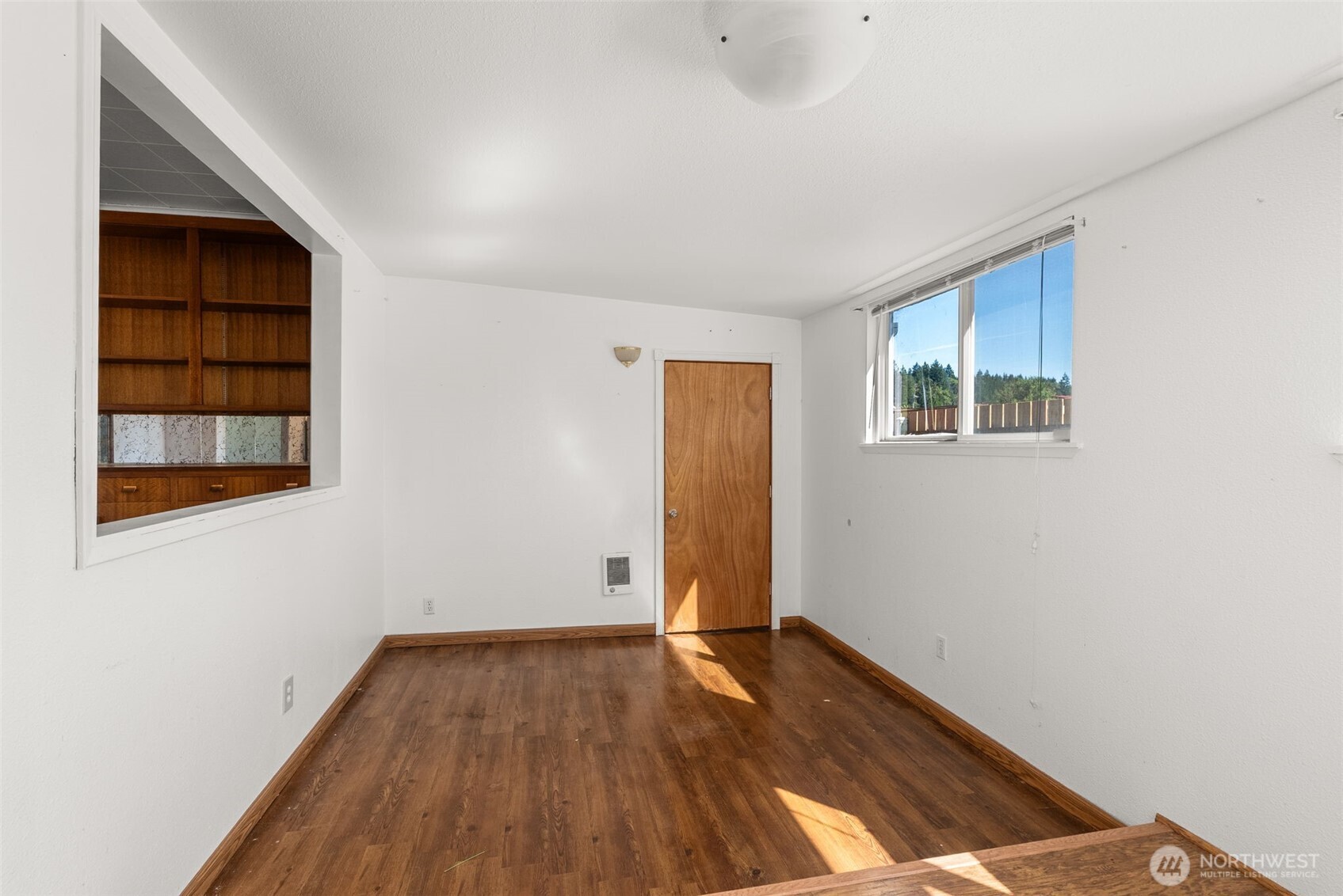 402 North 10th Street Elma, WA 98541 - Photo 15 of 35 an empty room with wooden floor and windows