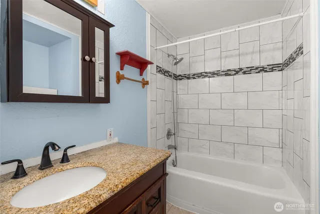a bathroom with a granite countertop sink and a mirror