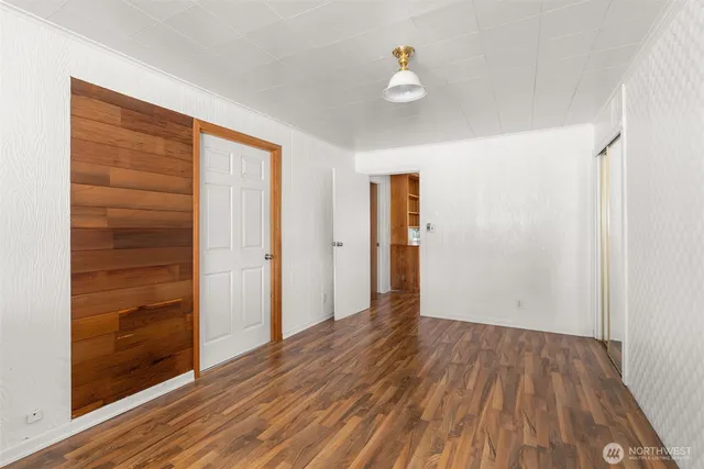 a view of an empty room with wooden floor