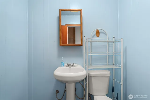 a bathroom with a sink a toilet and mirror
