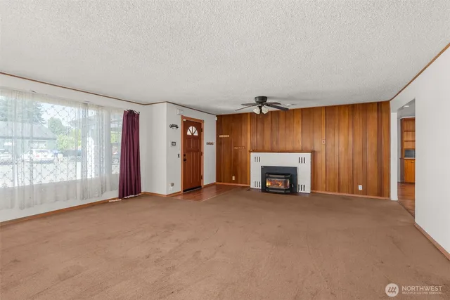 a view of an empty room with a fireplace and a window