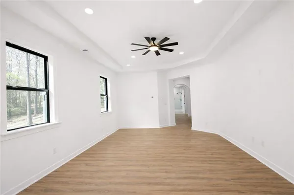 a spacious bathroom with a bathtub shower sink mirror and toilet