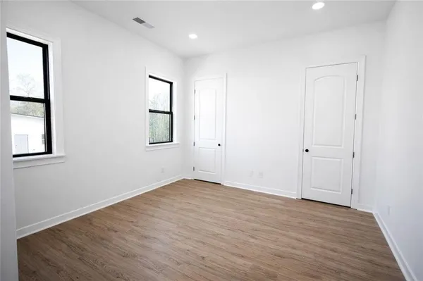 an empty room with wooden floor and entrance