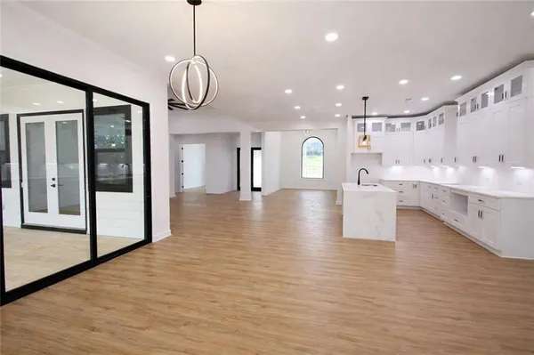 a view of a hallway with wooden floor and a bathroom