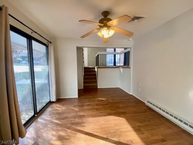 a view of empty room with a ceiling fan and window