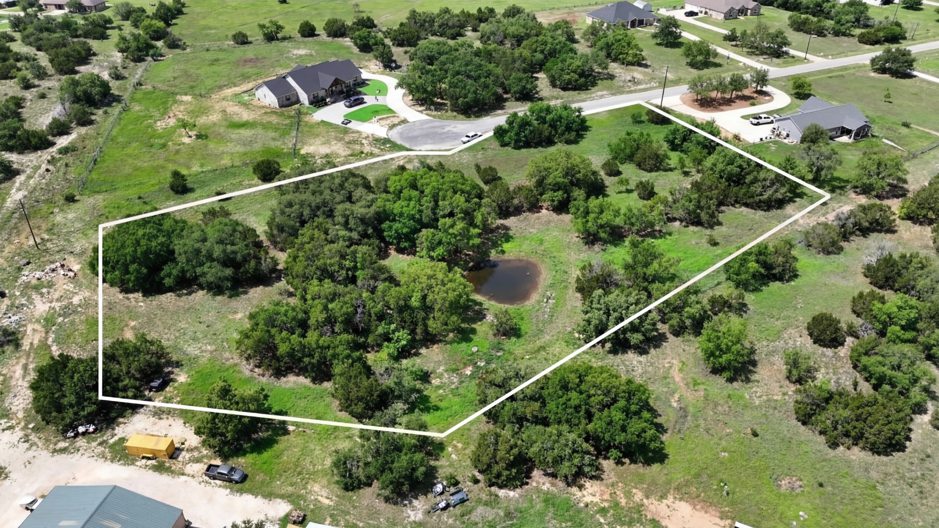 an aerial view of a residential houses with outdoor space and street view