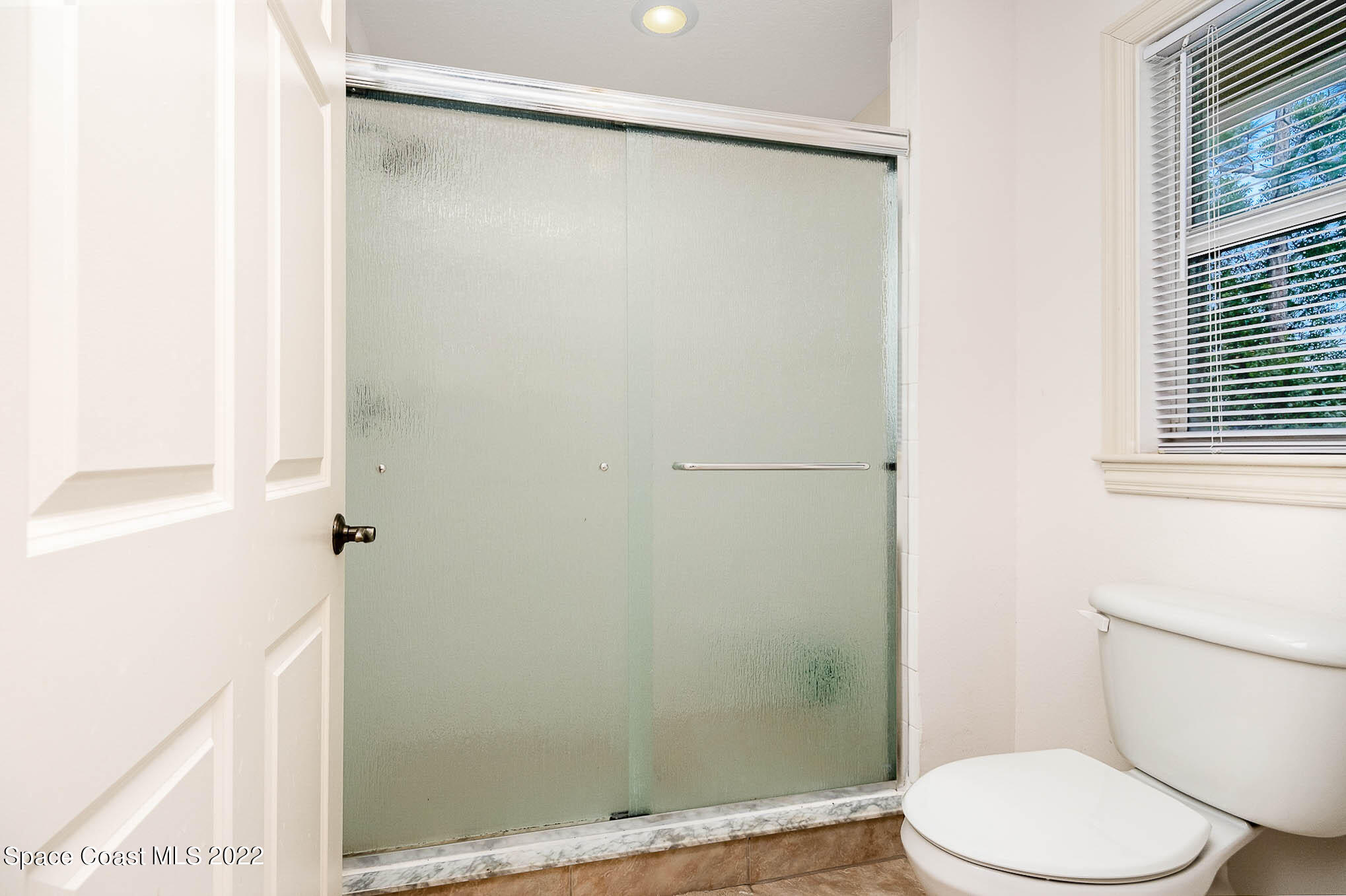 634 Cedar Side Circle Northeast Palm Bay, FL 32905 - Photo 17 of 24 a white toilet sitting next to a shower