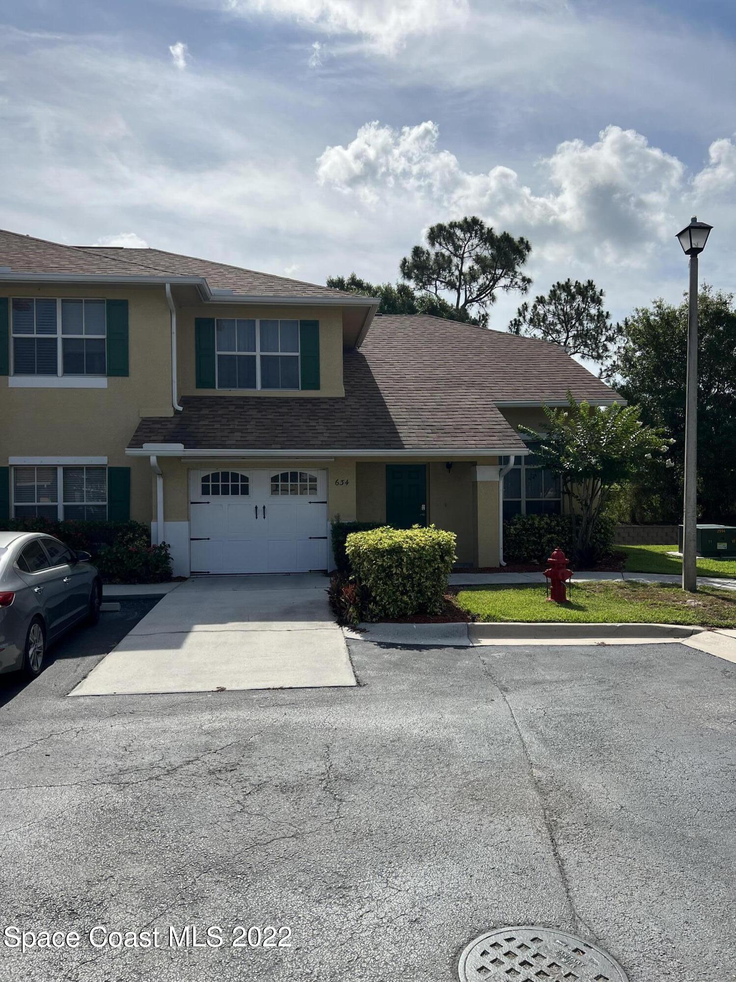 634 Cedar Side Circle Northeast Palm Bay, FL 32905 - Photo 5 of 24 a view of a house with a yard and a car park side of the road