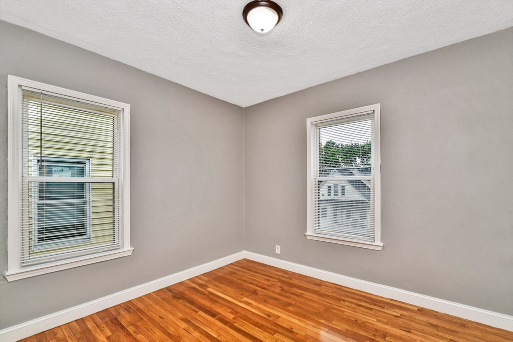 352 Norfolk Street, Unit 3 Boston, MA 02124 - Photo 7 of 12 a view of empty room with window and wooden floor