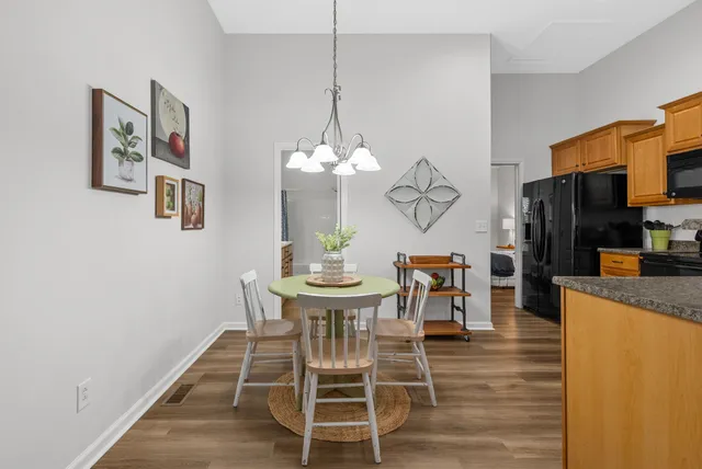 a dining room filled chandelier and wooden floor