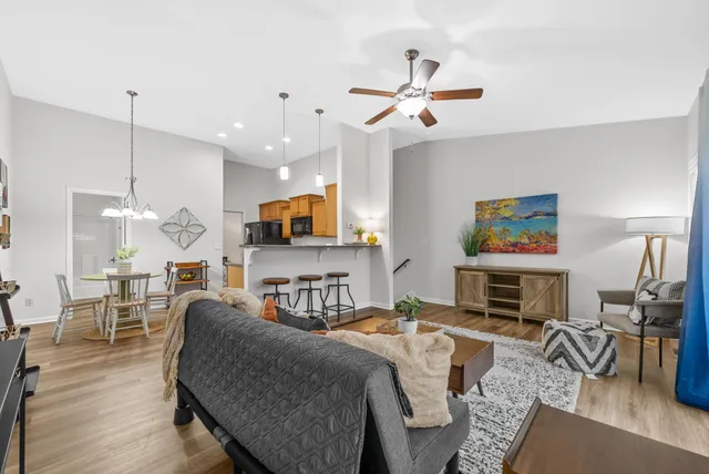 a kitchen with stainless steel appliances granite countertop a stove a sink dishwasher a refrigerator and a oven with wooden floor