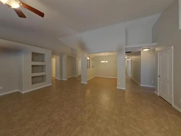 an empty room with windows and ceiling fan