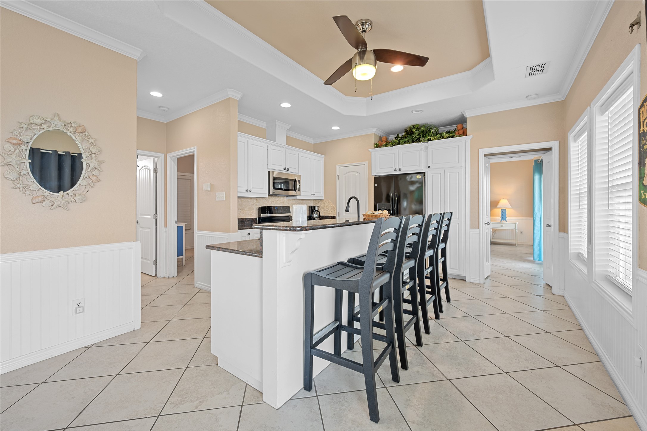 740 Copano Cove Road Rockport, TX 78382 - Photo 17 of 35 a kitchen with stainless steel appliances kitchen island granite countertop a table chairs and a refrigerator
