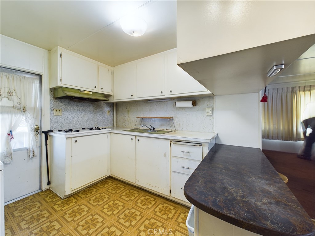 16600 Orange Avenue, Unit 55 Paramount, CA 90723 - Photo 7 of 18 a kitchen with granite countertop a sink stainless steel appliances and cabinets