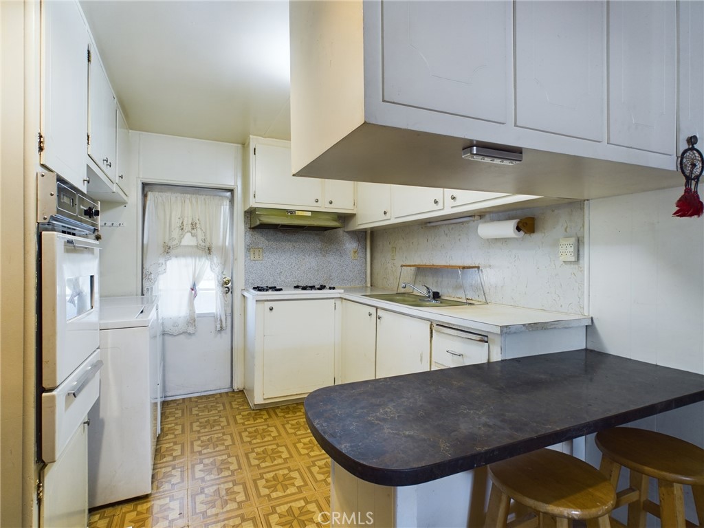 16600 Orange Avenue, Unit 55 Paramount, CA 90723 - Photo 8 of 18 a kitchen with cabinets and wooden floor