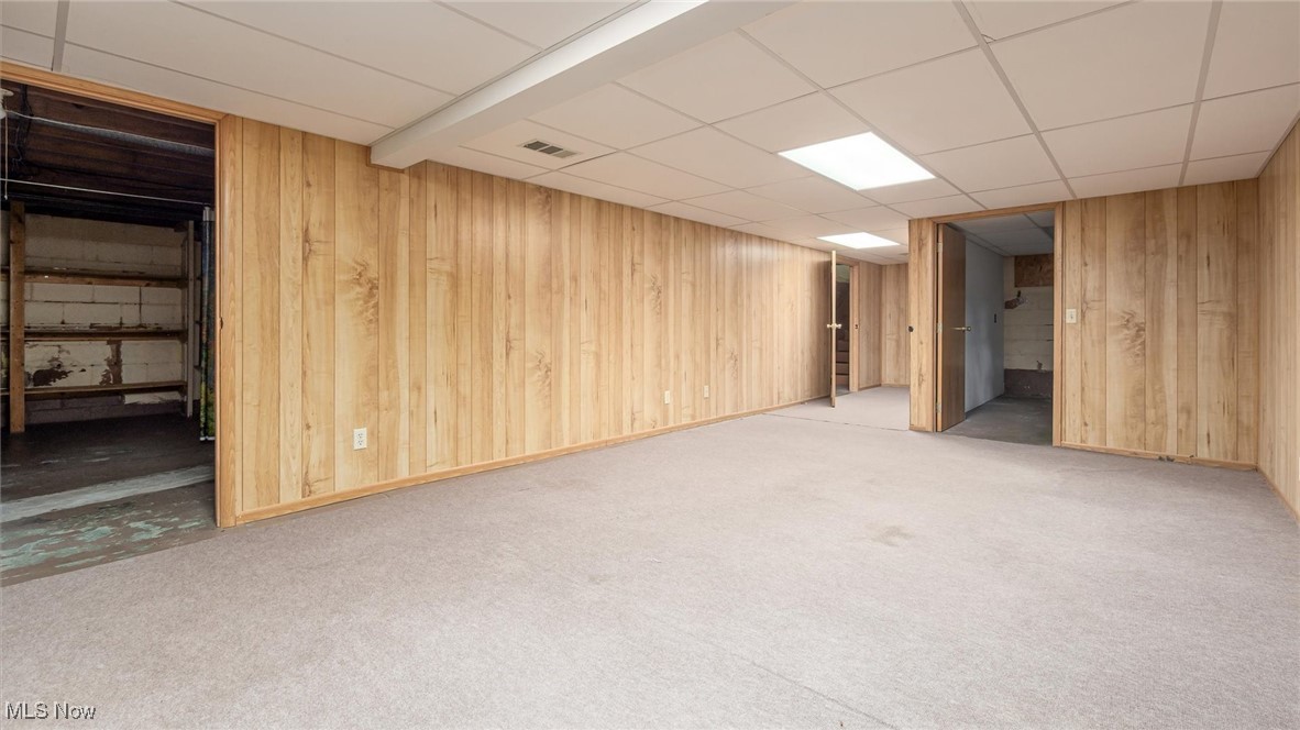 427 Harding Road Zanesville, OH 43701 - Photo 18 of 23 Finished basement featuring wooden walls, a drop ceiling, and light carpet