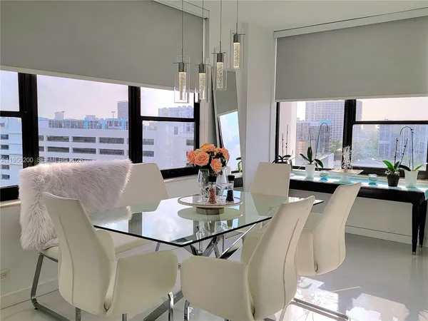 a dining room with furniture and a floor to ceiling window