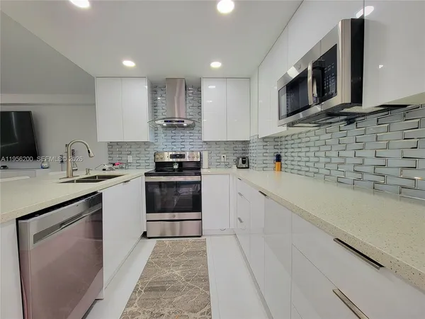 a kitchen with stainless steel appliances stove microwave sink and cabinets