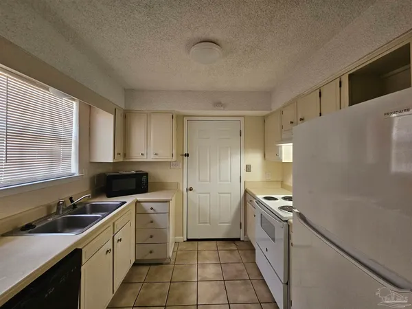 a kitchen with a sink a refrigerator and cabinets