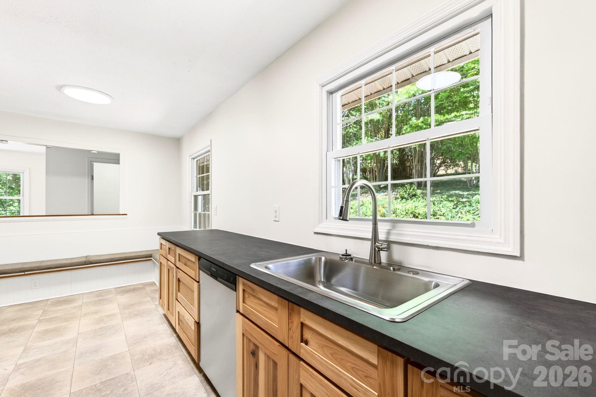 34 Wolfe Cove Road Asheville, NC 28804 - Photo 26 of 42 a kitchen that has a sink stainless steel appliances cabinets and a large window
