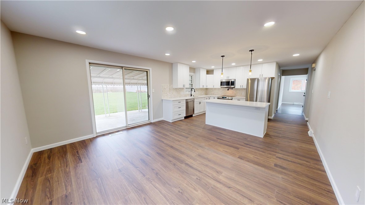 1224 Cordova Road Mayfield Heights, OH 44124 - Photo 13 of 29 Kitchen with appliances with stainless steel finishes, white cabinets, a healthy amount of sunlight, and dark hardwood / wood-style floors
