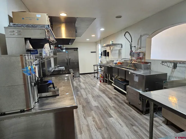 a kitchen with kitchen island a stove and a wooden floors