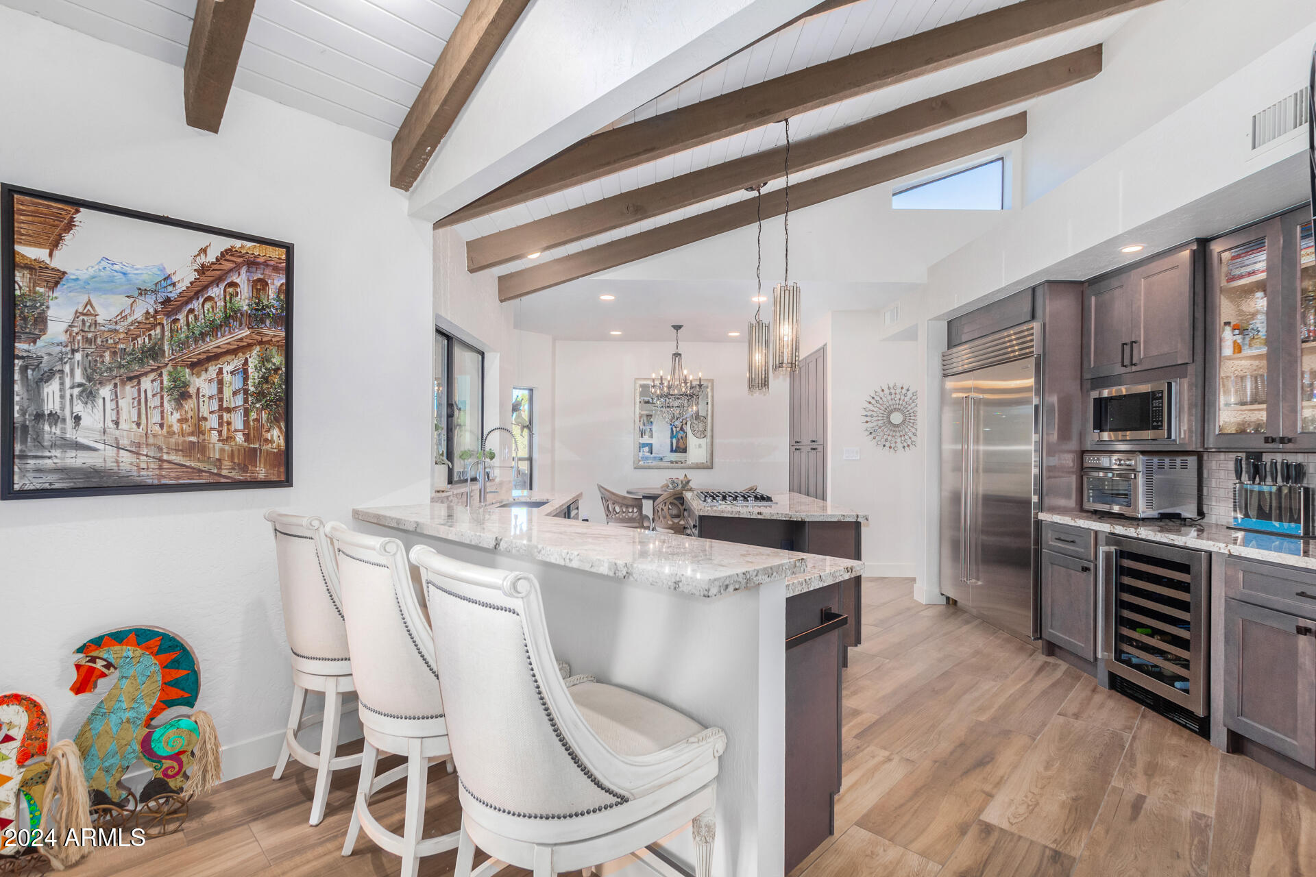 9446 Romping Road Carefree, AZ 85377 - Photo 32 of 119 a dining room with stainless steel appliances furniture a kitchen view and a chandelier