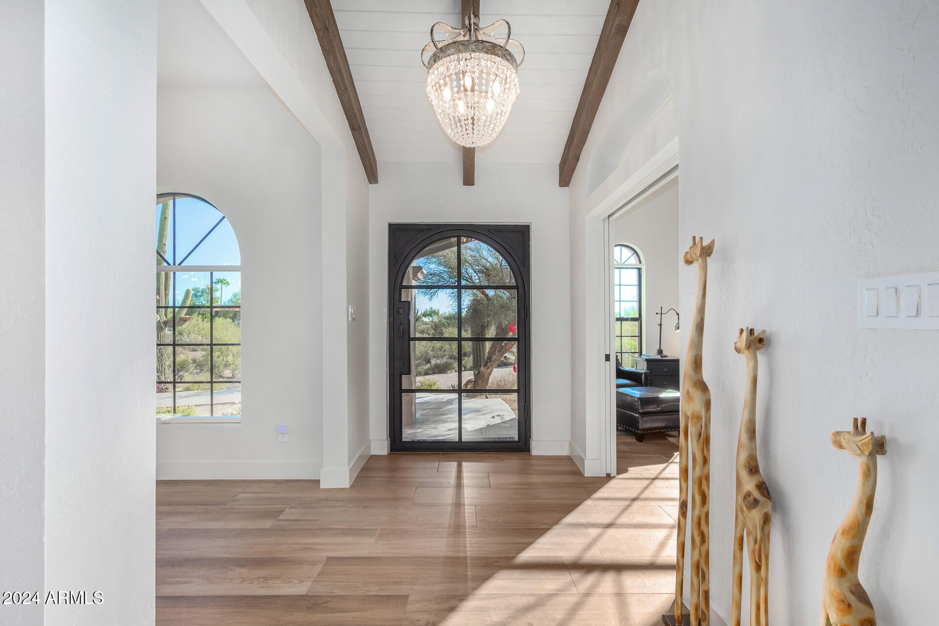 9446 Romping Road Carefree, AZ 85377 - Photo 7 of 119 a view of a hallway with wooden floor and a chandelier